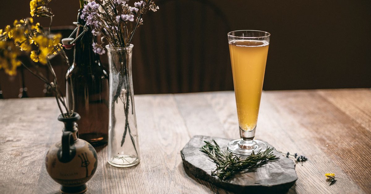 beer and herbs in vases against moody background